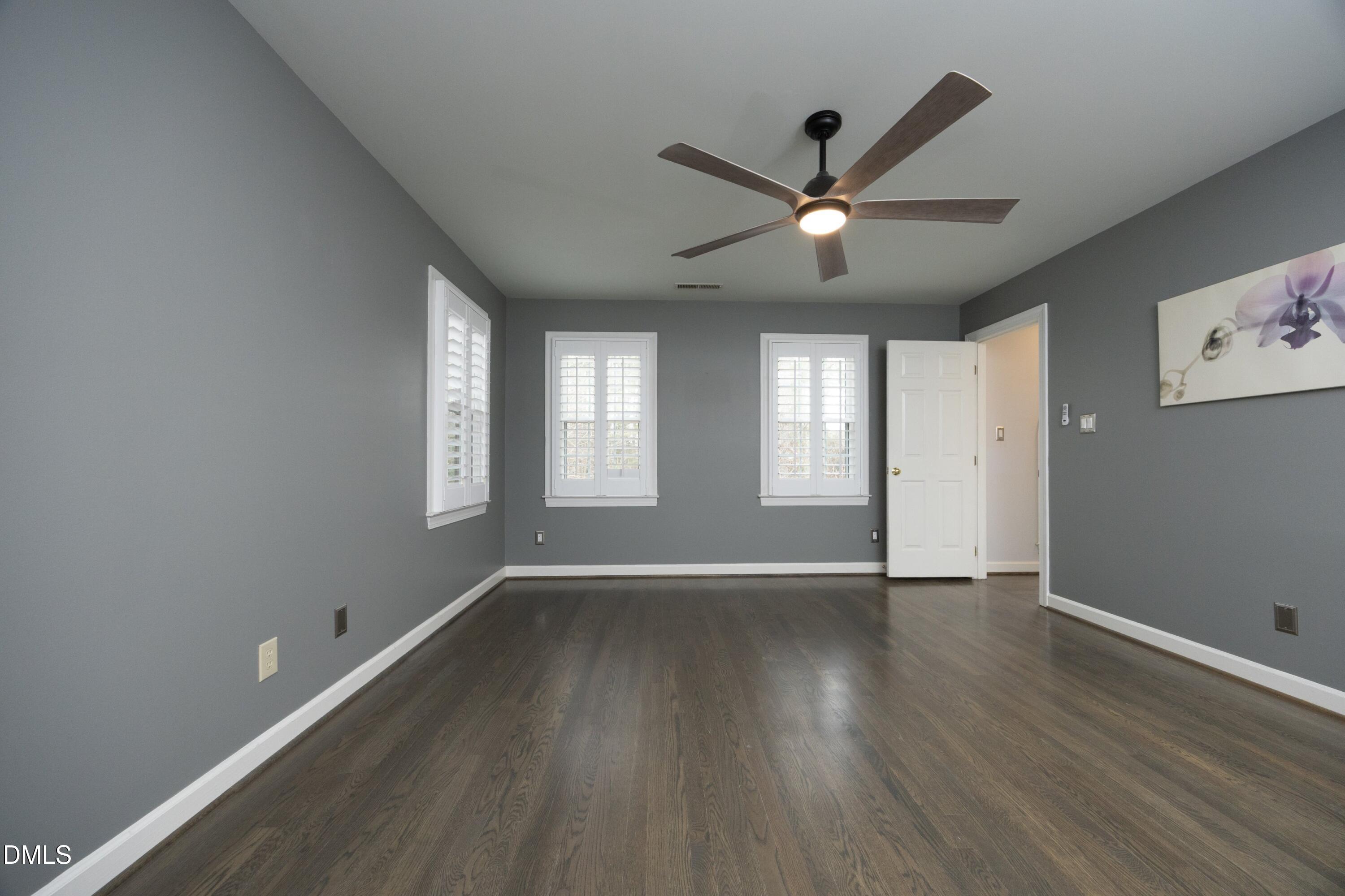 10728 Winding Wood Trail Raleigh, NC 27613 - Photo 19 of 54 a view of an empty room with wooden floor and a window