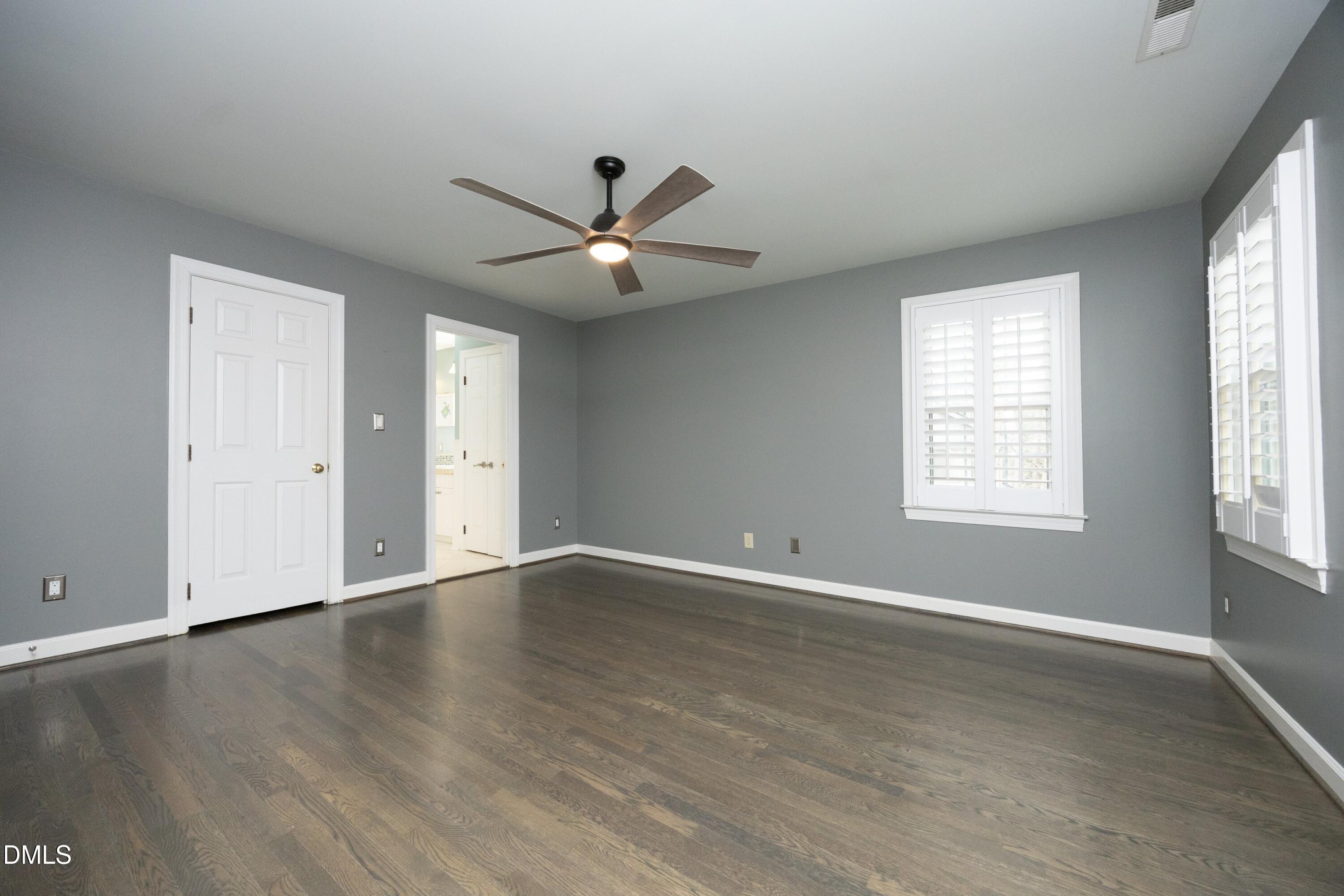 10728 Winding Wood Trail Raleigh, NC 27613 - Photo 20 of 54 an empty room with wooden floor and windows
