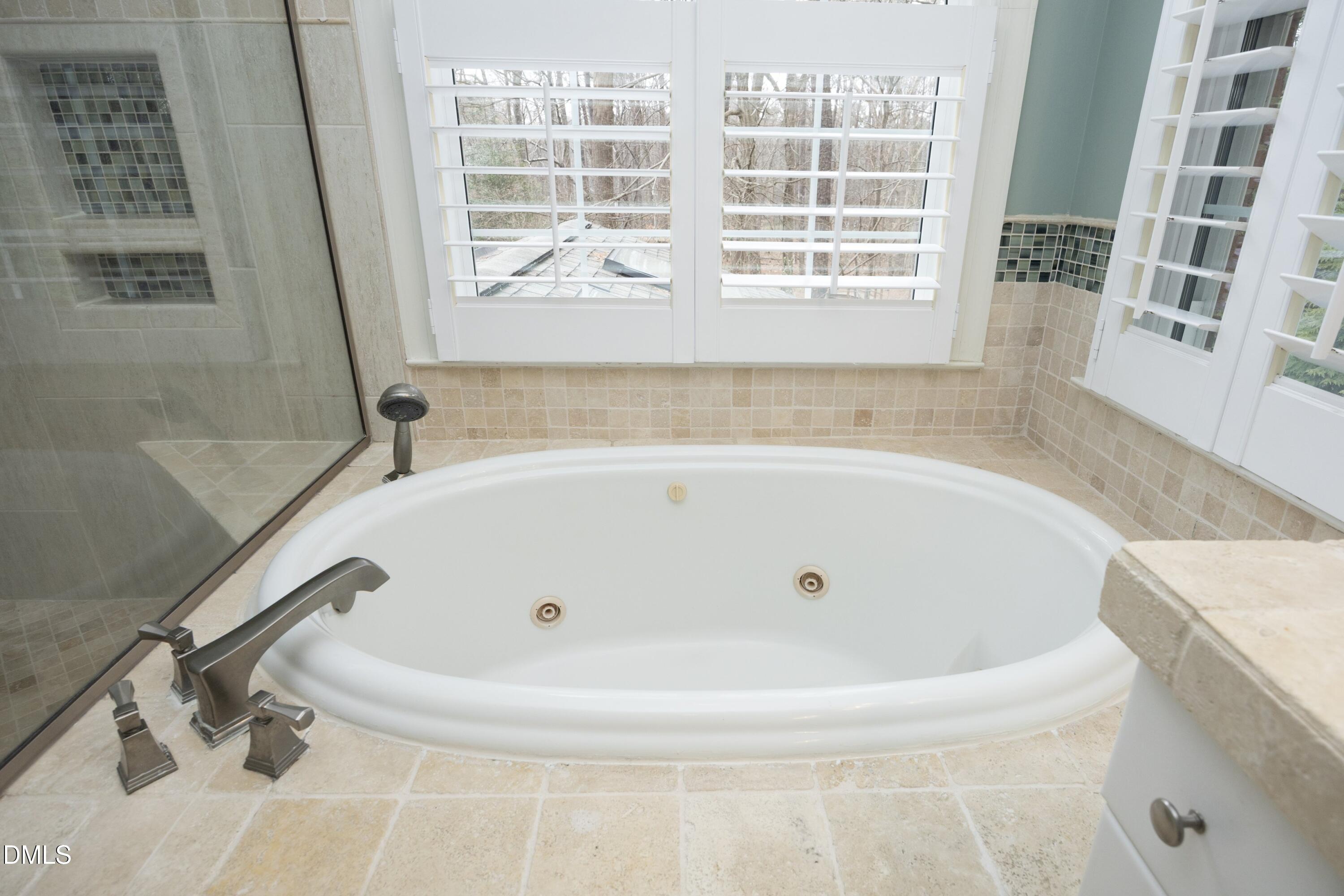 10728 Winding Wood Trail Raleigh, NC 27613 - Photo 22 of 54 a white bath tub sitting in a bathroom next to a window