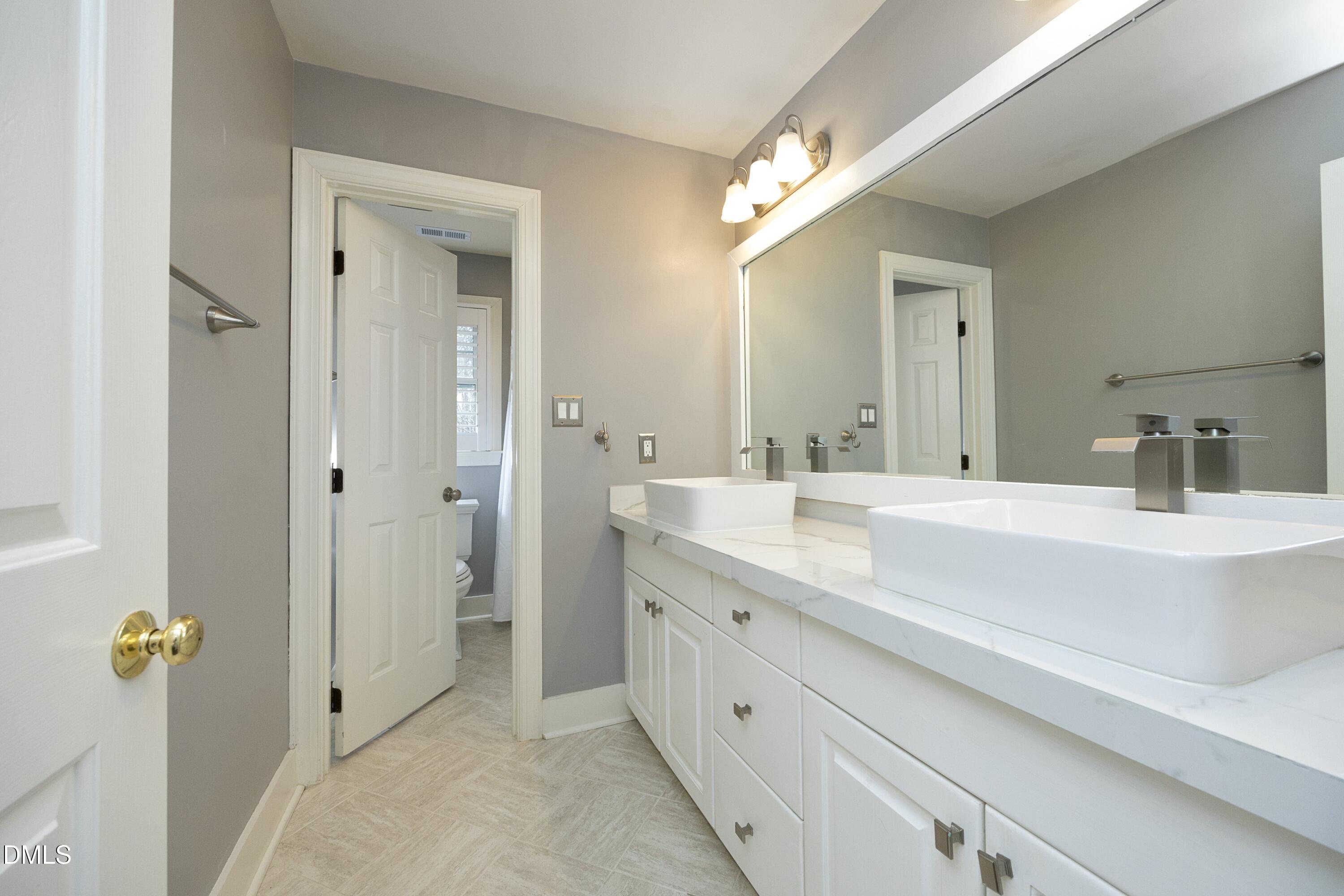 10728 Winding Wood Trail Raleigh, NC 27613 - Photo 27 of 54 a bathroom with a sink double vanity granite and a mirror