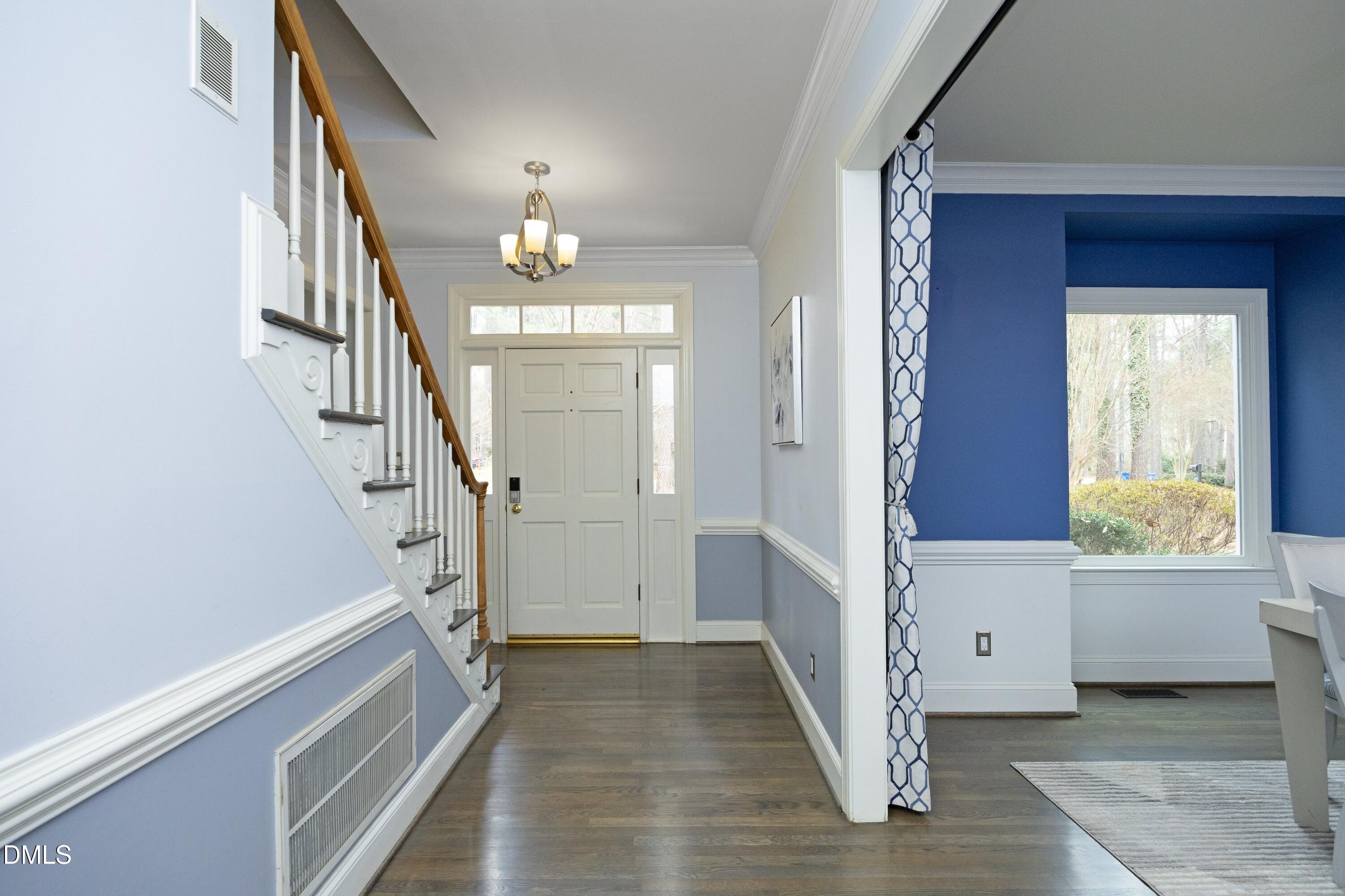 10728 Winding Wood Trail Raleigh, NC 27613 - Photo 3 of 54 a view of a hallway with wooden floor and staircase