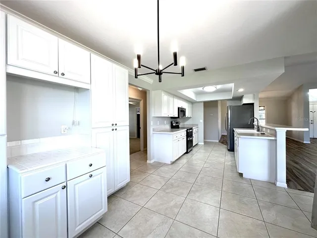 a kitchen with kitchen island granite countertop a sink counter top space appliances and cabinets