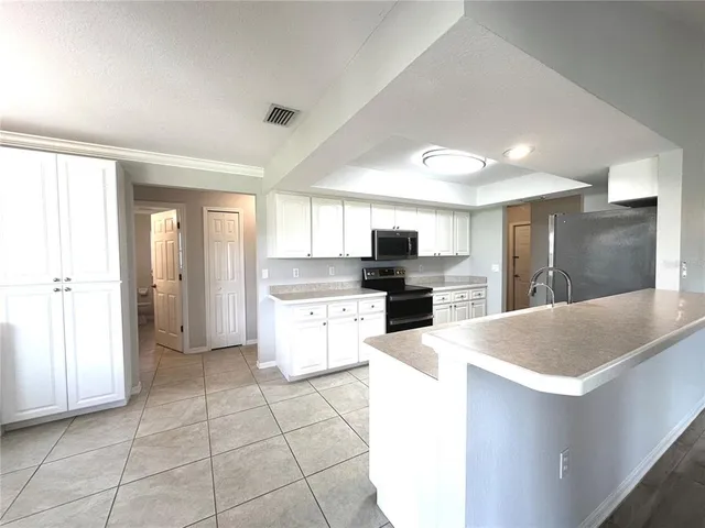 a kitchen with stainless steel appliances kitchen island granite countertop a refrigerator and a sink
