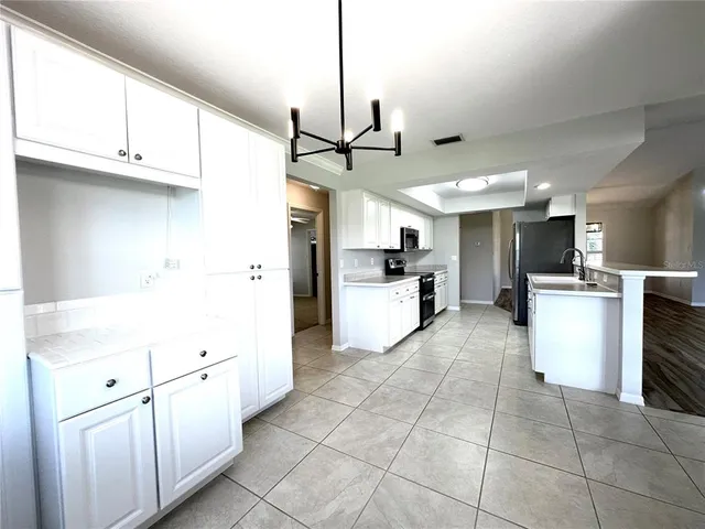 a kitchen with white cabinets and white appliances