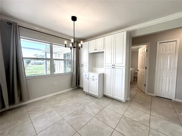 a view of a kitchen with a refrigerator and a chandelier