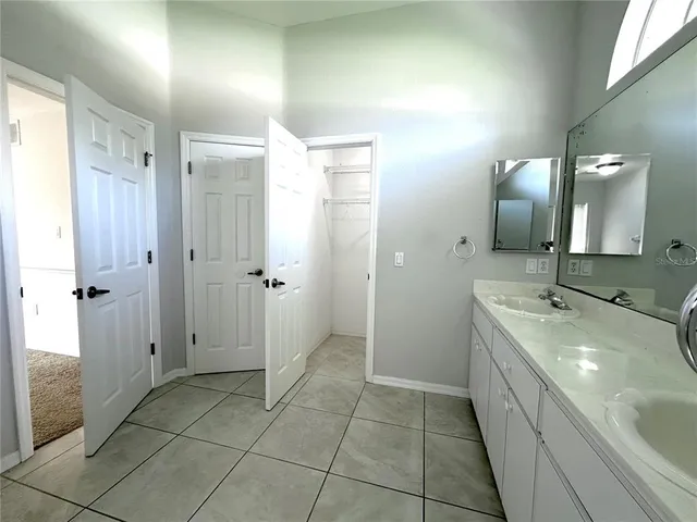 a spacious bathroom with a double vanity sink a mirror and a shower