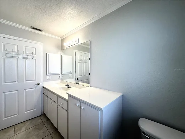 a bathroom with a granite countertop sink mirror and a toilet