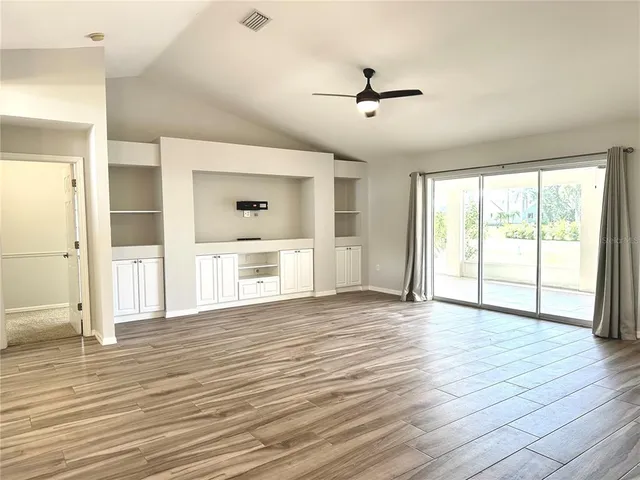 a view of a livingroom with wooden floor and a ceiling fan