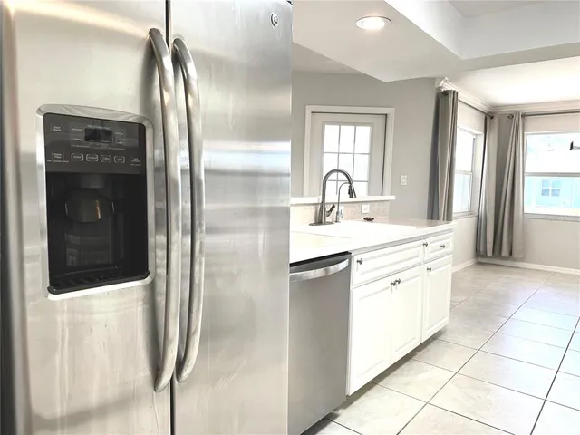a large kitchen with stainless steel appliances a refrigerator and a sink