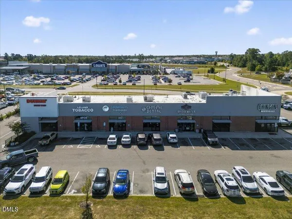 an aerial view of a residential houses with outdoor space and trees all around
