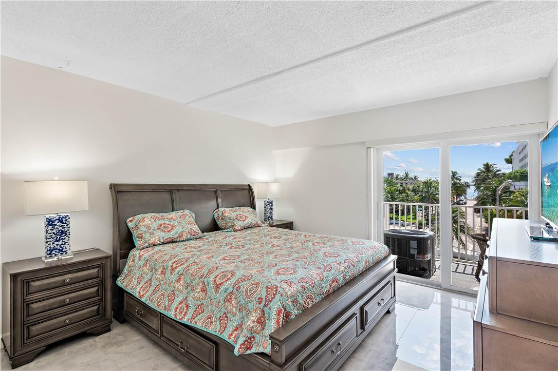 95 North Birch Road, Unit 405 Fort Lauderdale, FL 33304 - Photo 12 of 34 a bedroom with a large bed and a large window