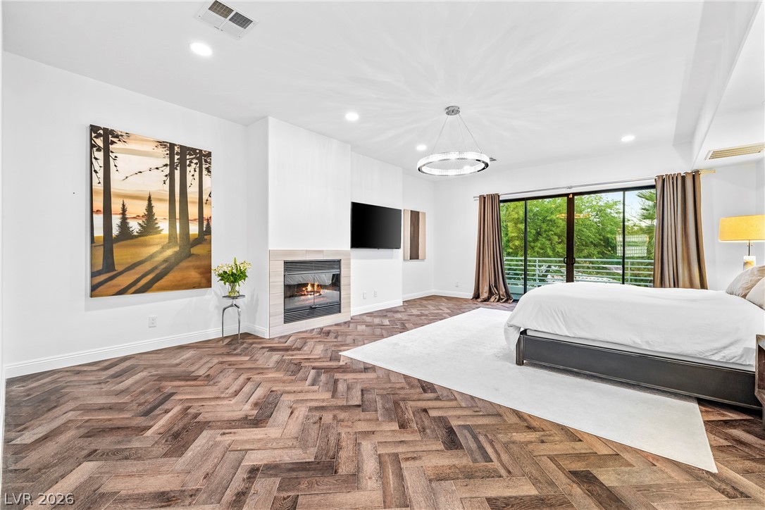 2000 Grouse Street Las Vegas, NV 89134 - Photo 38 of 89 Herringbone wood flooring and a modern fireplace create a welcoming ambiance in this primary suite.