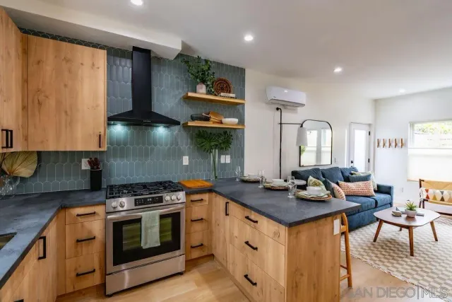 a kitchen with stainless steel appliances a stove a sink dishwasher and cabinets with wooden floor