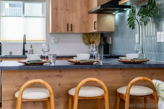 a kitchen with chairs a sink and a stove