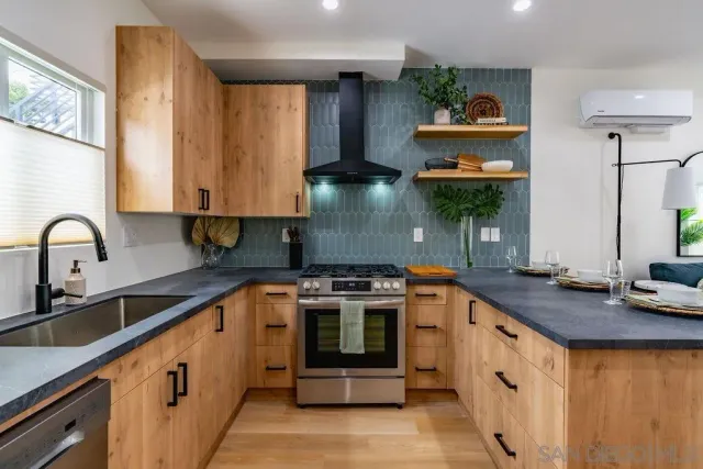 a kitchen with stainless steel appliances granite countertop a stove and a sink