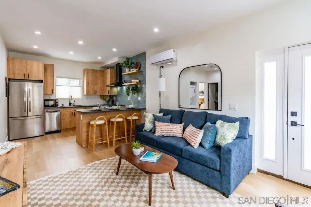 a living room with furniture and kitchen view
