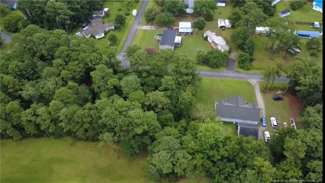an aerial view of residential house with outdoor space and trees all around