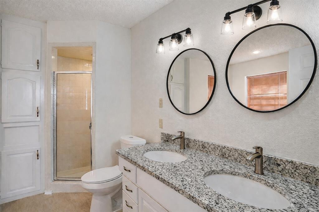 3017 Freeman Lane Crowley, TX 76036 - Photo 27 of 39 a bathroom with a granite countertop toilet a sink and a mirror