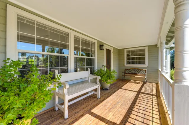a view of a house with a yard and potted plants