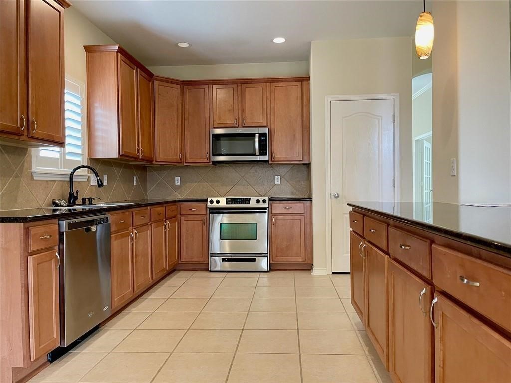 7505 Bell Isle Corpus Christi, TX 78414 - Photo 5 of 24 a kitchen with stainless steel appliances a stove sink microwave and cabinets