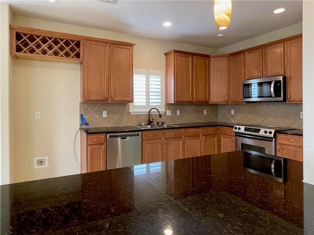 7505 Bell Isle Corpus Christi, TX 78414 - Photo 6 of 24 a kitchen with granite countertop a stove a sink and a microwave