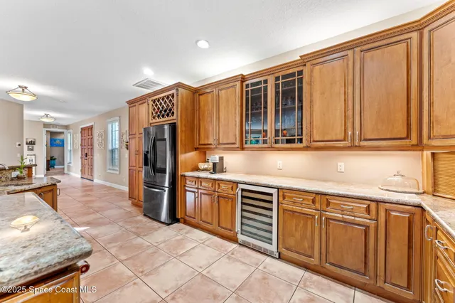 a kitchen with stainless steel appliances kitchen island granite countertop a table chairs and a refrigerator