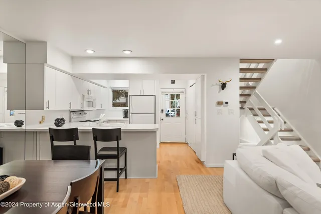 a large white kitchen with stainless steel appliances kitchen island granite countertop a sink and cabinets