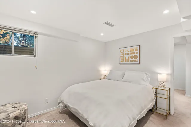 a bedroom with a bed and painting on the wall