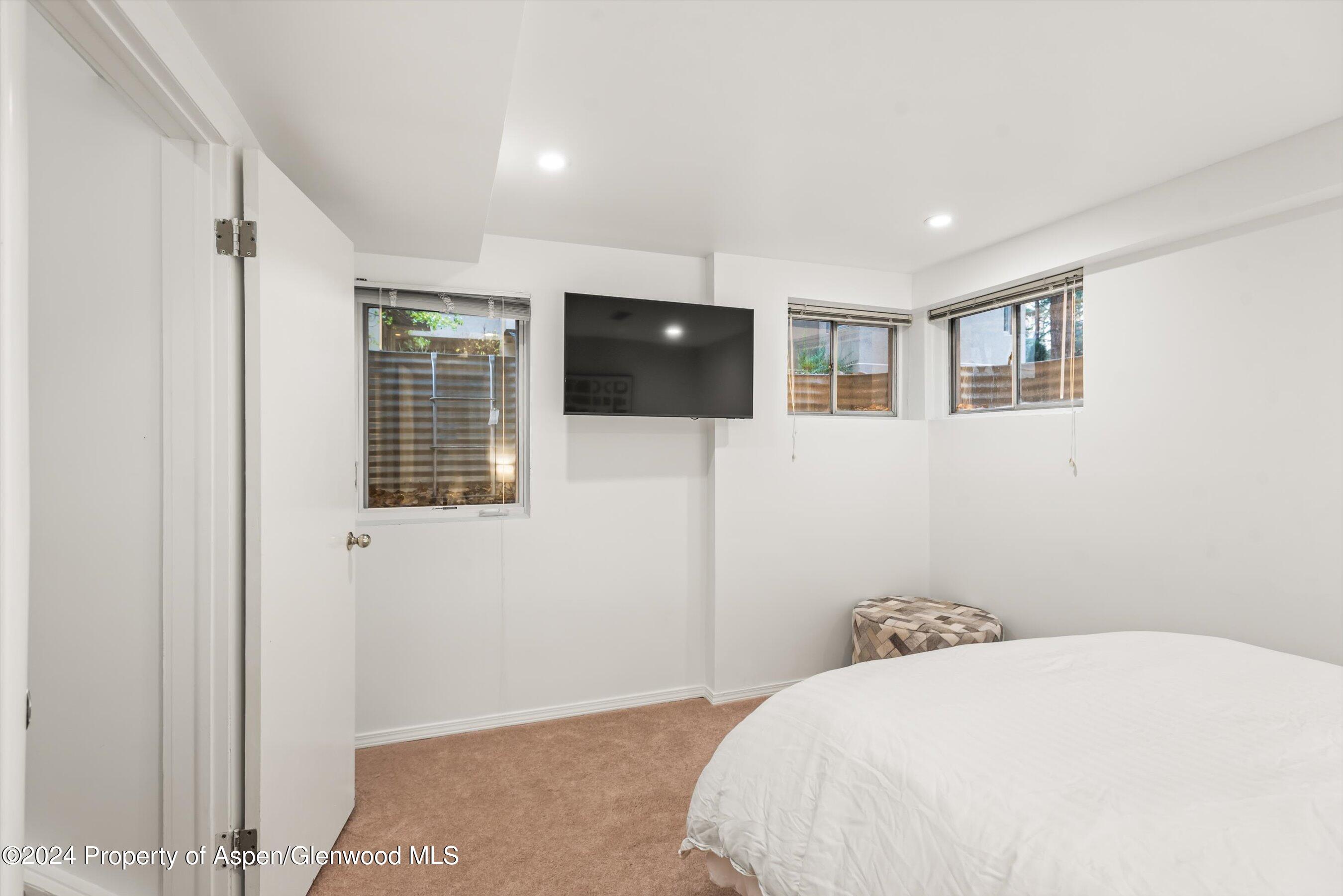 814 West Bleeker Street, Unit D1 Aspen, CO 81611 - Photo 19 of 22 a bedroom with a bed and a flat screen tv