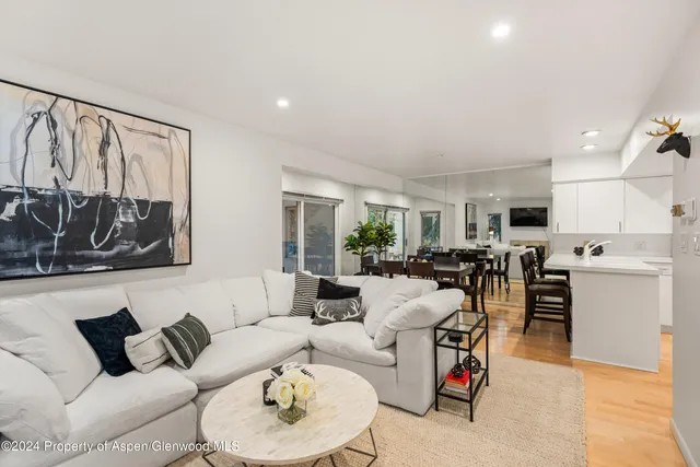 a living room with furniture kitchen view and a window