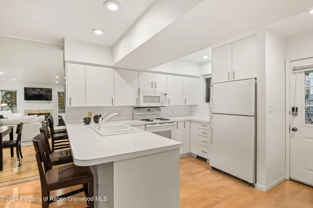 a kitchen with a refrigerator a stove a sink and chairs