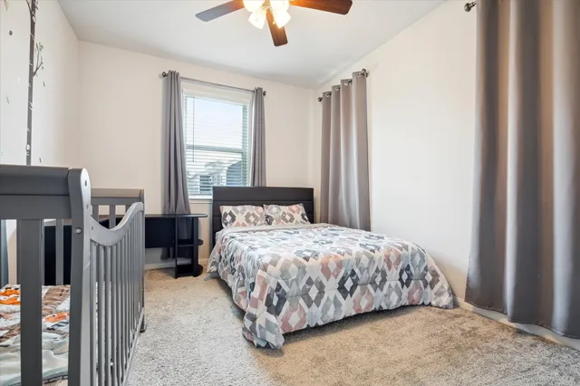 a bedroom with a bed next to a window with a flat screen tv