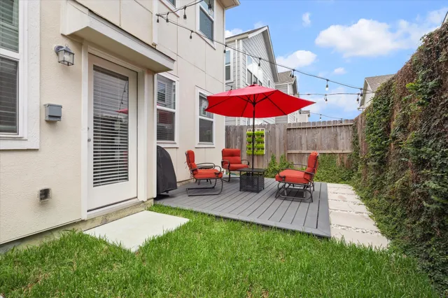 a view of a patio with a table and chairs under an umbrella