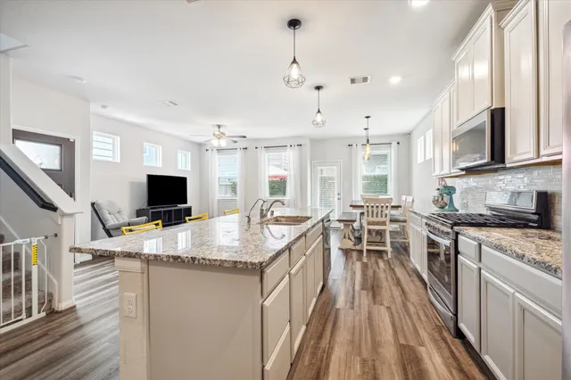 a kitchen with sink stove and cabinets