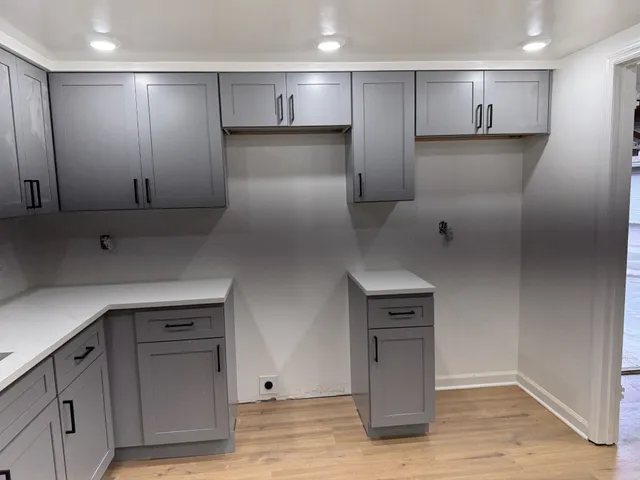 a kitchen with kitchen island white cabinets and stainless steel appliances