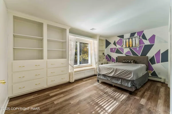 an empty room with wooden floor fireplace and windows