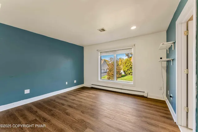 a view of a livingroom with wooden floor and a fireplace