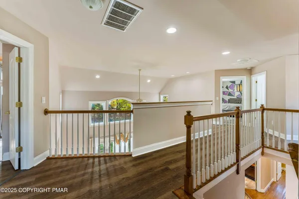 a view of a hallway with wooden floor and entryway