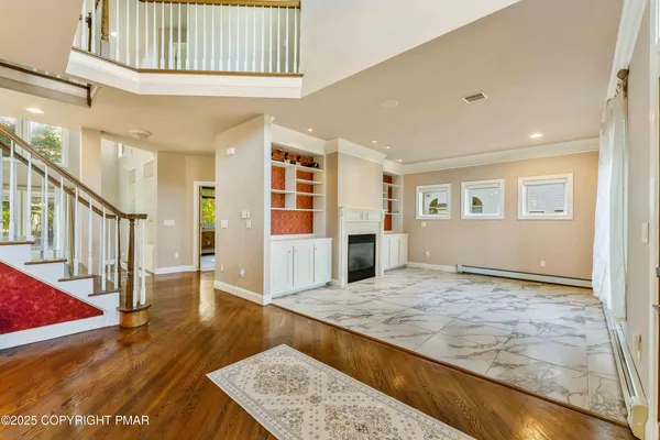 a kitchen with stainless steel appliances granite countertop a stove top oven a sink a dining table and chairs with wooden floor