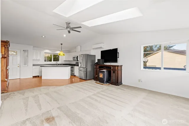 a large white kitchen with a stove top oven a sink dishwasher and a fireplace