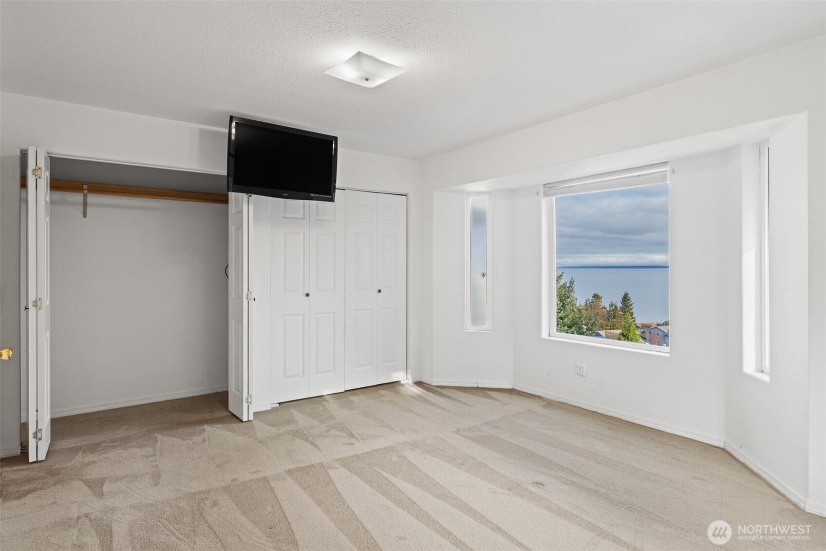 233 Lupine Drive Sequim, WA 98382 - Photo 21 of 40 a view of an empty room with a window and a flat screen tv