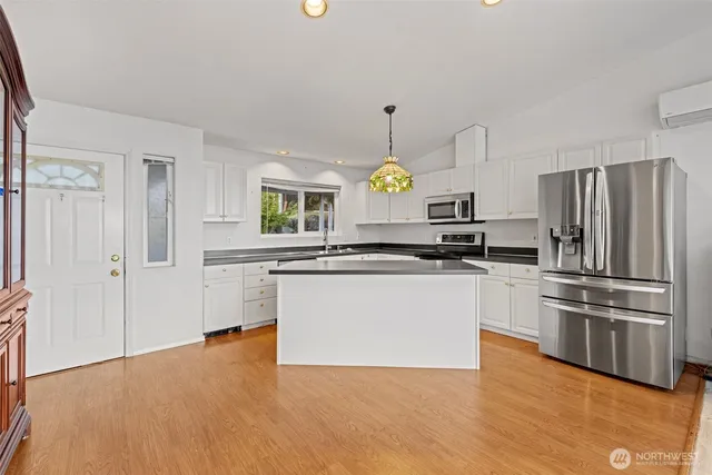 a kitchen with a refrigerator and a stove top oven