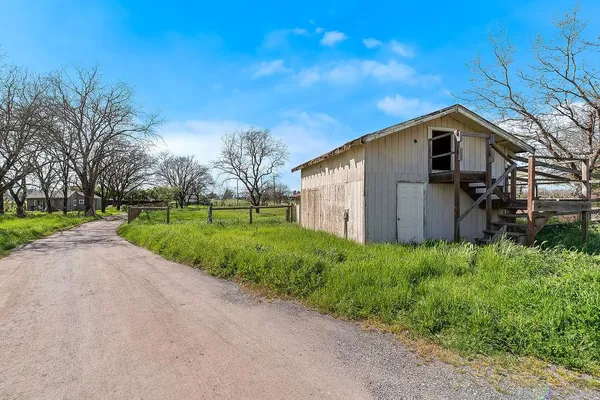 a house with green field in front of it