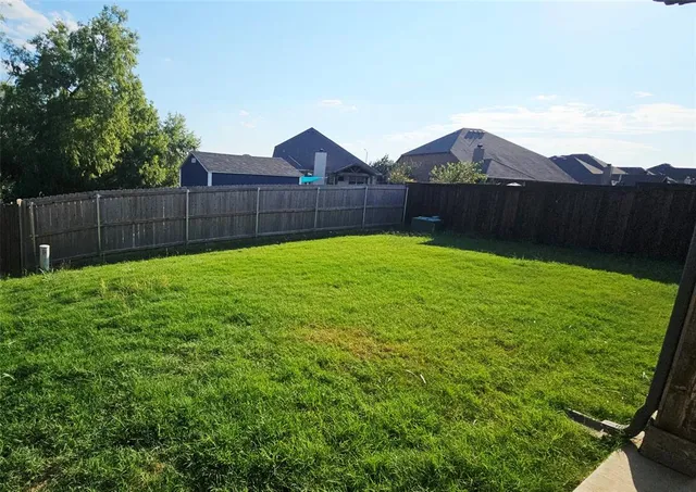 a view of backyard with wooden fence