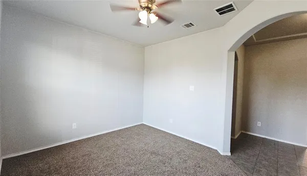 an empty room with a ceiling fan and a window