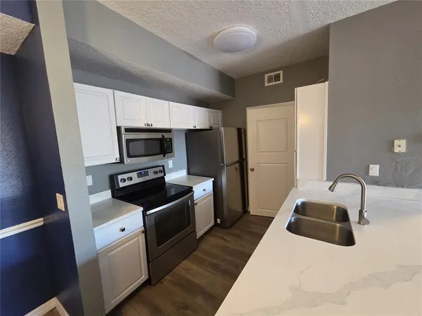 a kitchen with white cabinets and stainless steel appliances