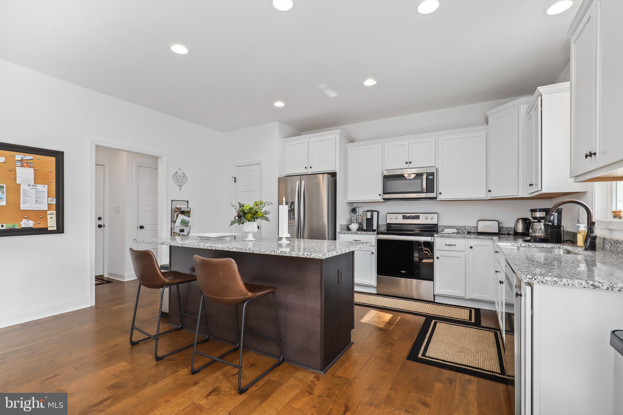 225 Raven Road Bumpass, VA 23024 - Photo 17 of 46 a kitchen with a table chairs microwave and cabinets