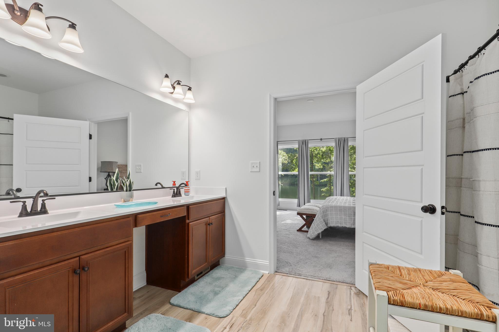 225 Raven Road Bumpass, VA 23024 - Photo 26 of 46 a en suite bathroom with a granite countertop sink and a mirror
