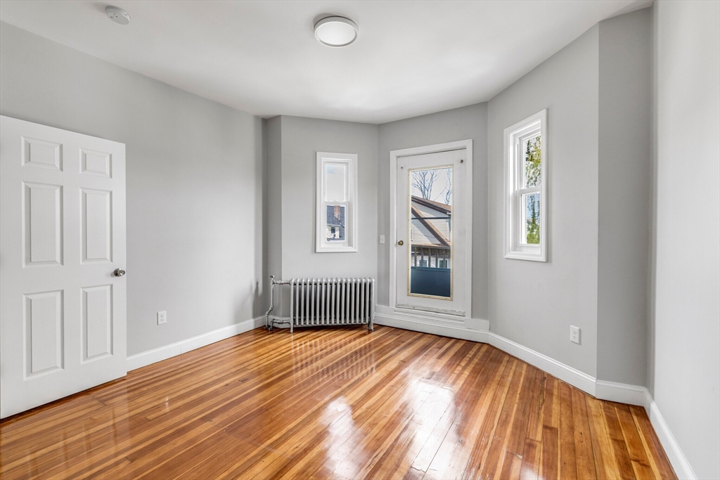 33 Wolcott Street, Unit 3 Boston, MA 02121 - Photo 4 of 8 a view of empty room with wooden floor