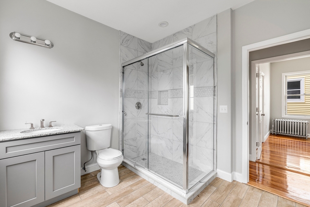 33 Wolcott Street, Unit 3 Boston, MA 02121 - Photo 7 of 8 a bathroom with a toilet a sink and shower